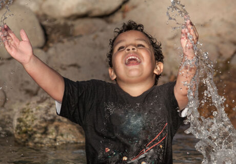 boy splashes in water at Kidspace