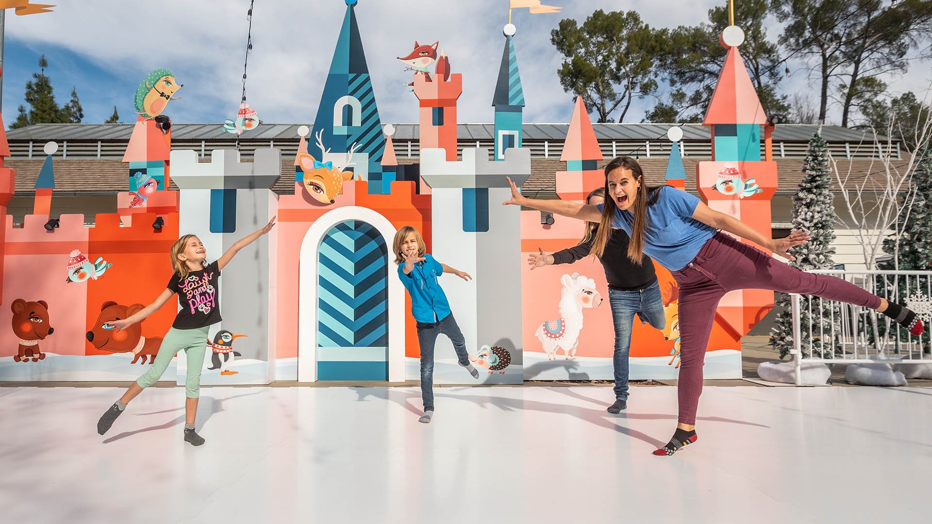 Familia de cuatro bailes en una pista de patinaje sobre calcetines