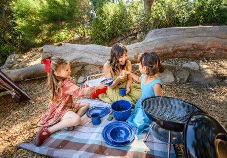 Dos niños y un adulto hacen un campamento de juegos.