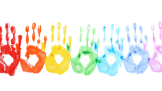 Handprints painted in rainbow colors