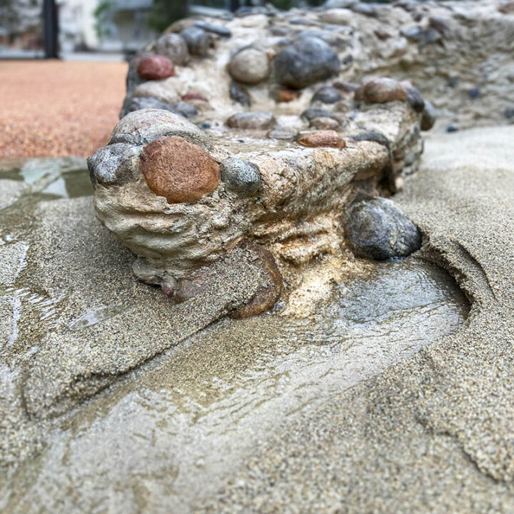 a stream of water flowing into sand