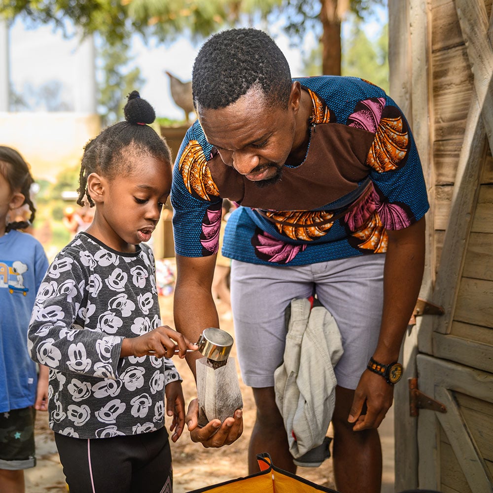 girls shows father how to plant seeds