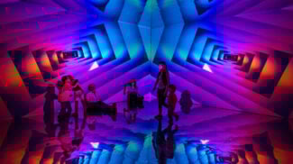 families play in a color infinity room with geometric patterns