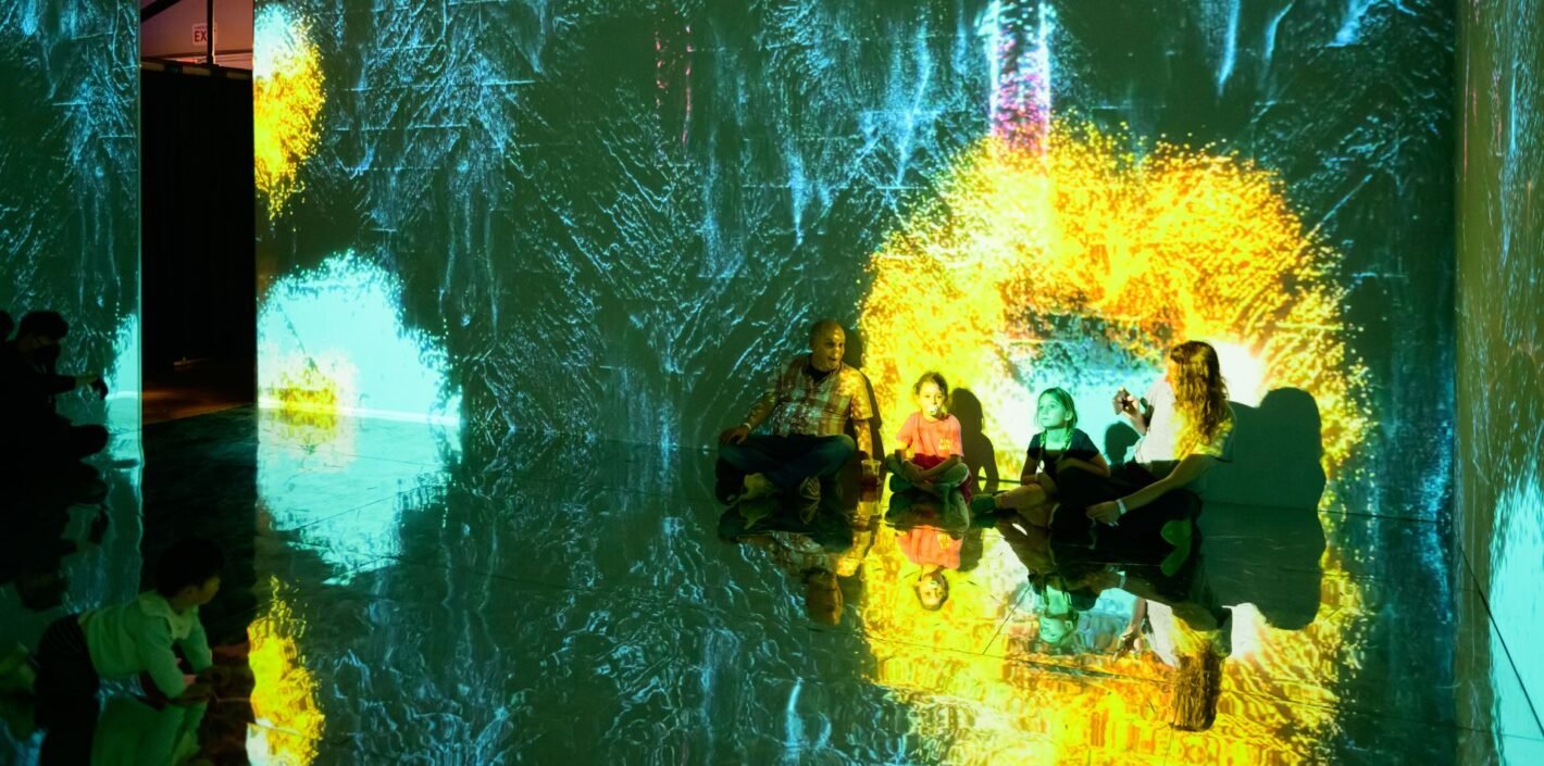 Family sits in brightly colored infinity room