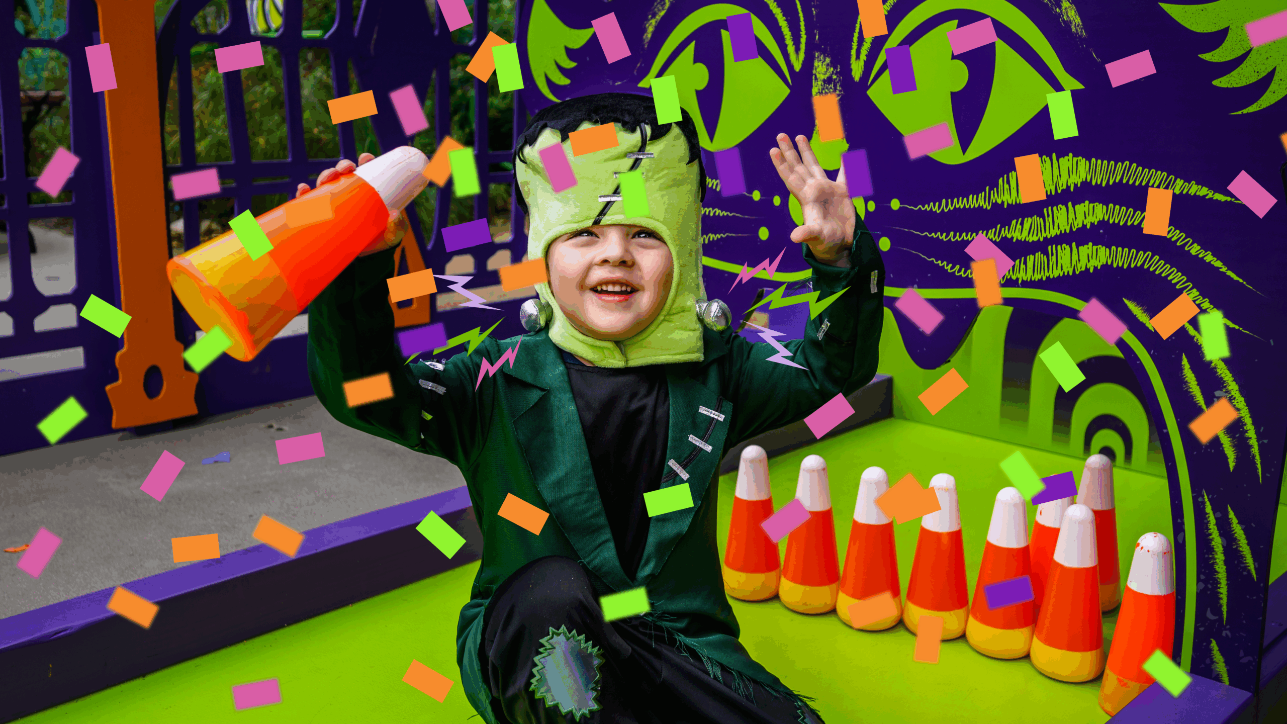 Child in costume holds up candy corn bowling pin
