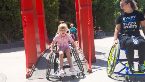 child in a wheelchair crosses a bridge