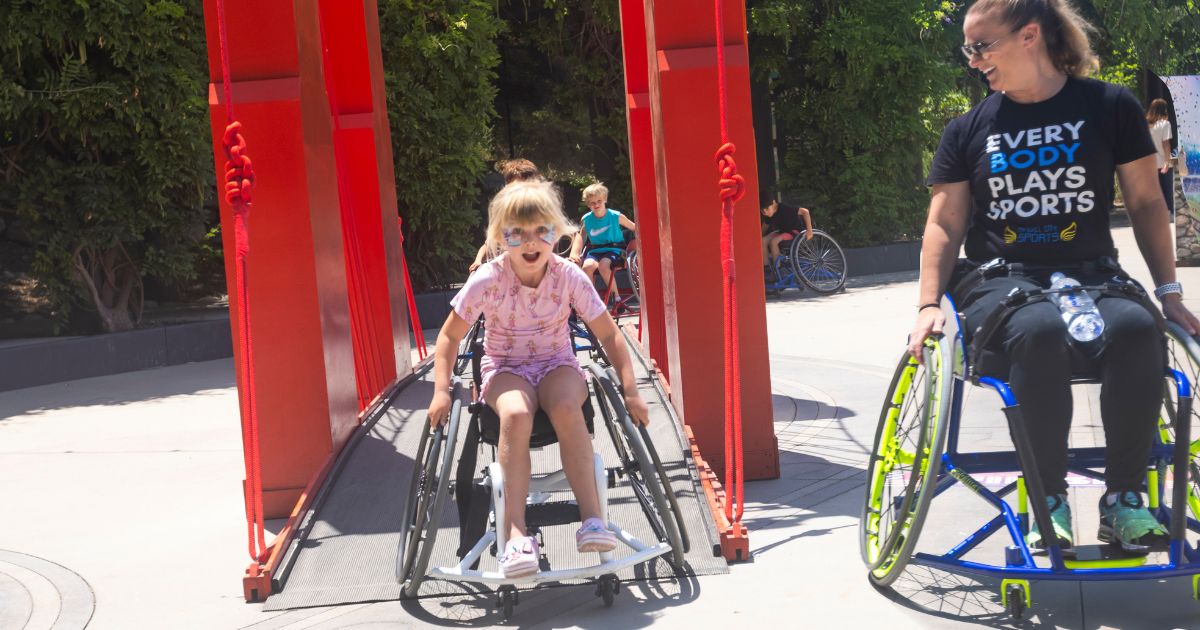 child in a wheelchair crosses a bridge