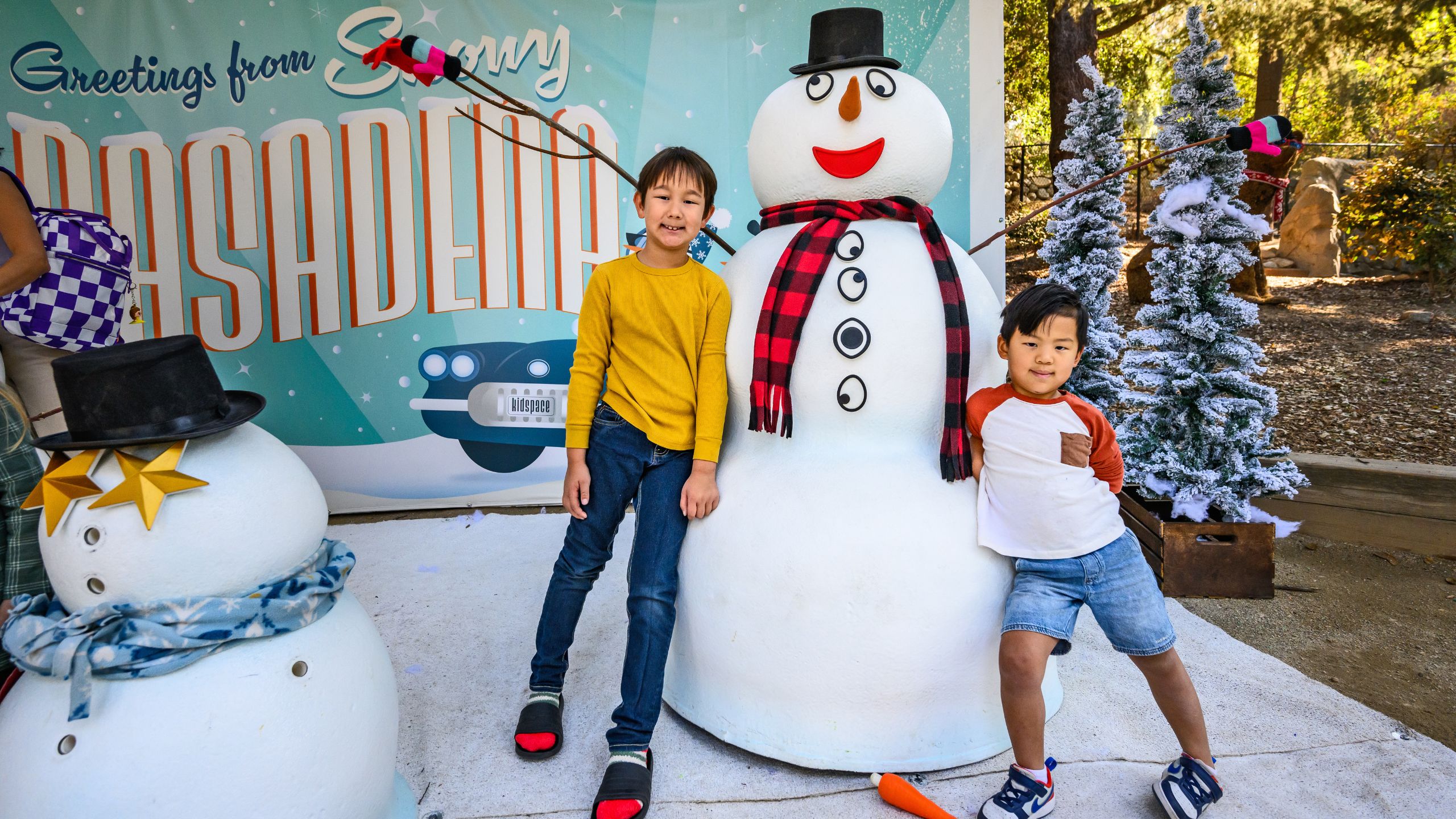 Two boys pose with play snowman