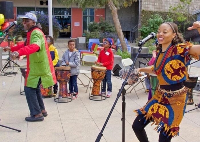 group of people dancing and children drumming