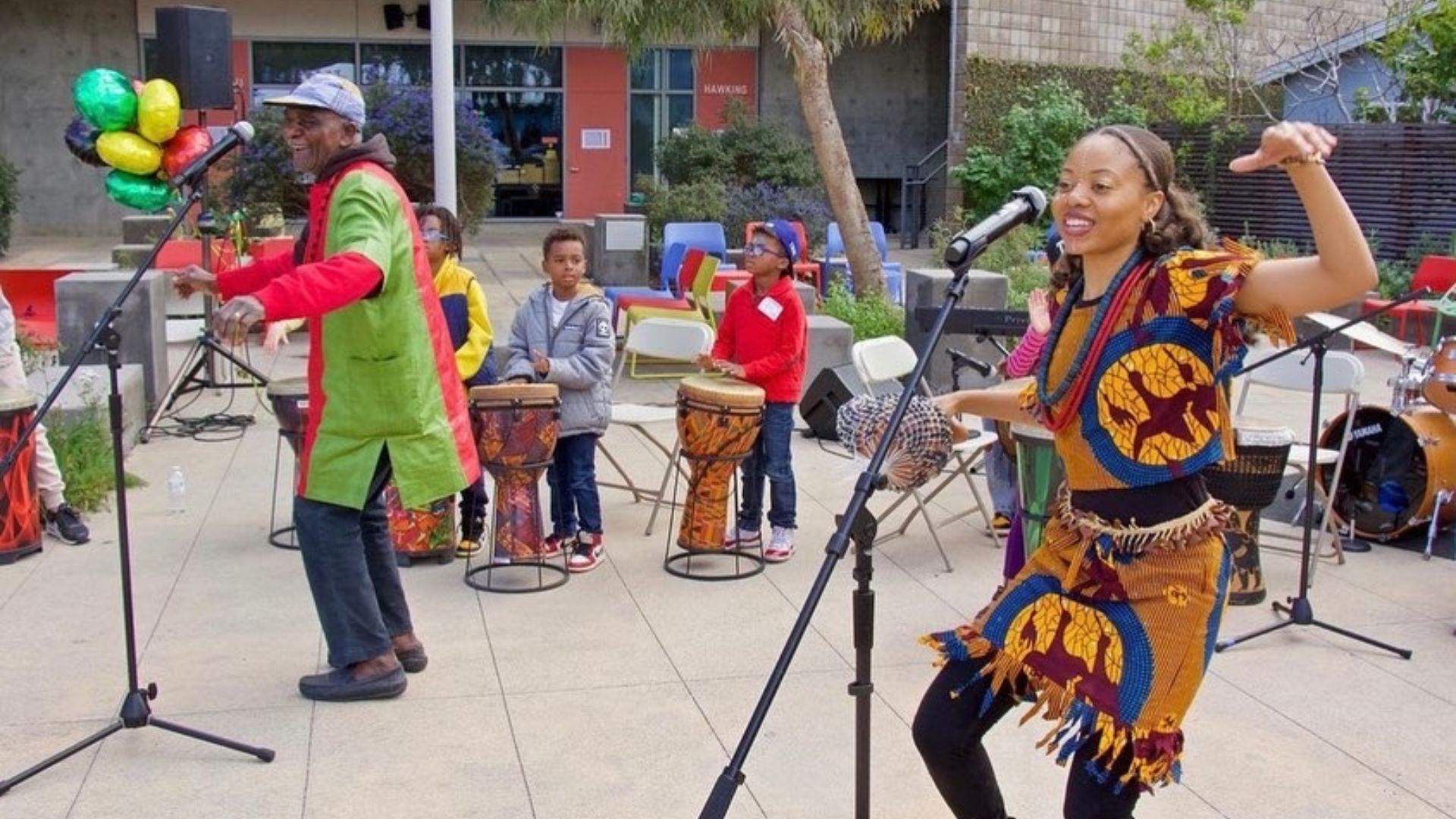 group of people dancing and children drumming