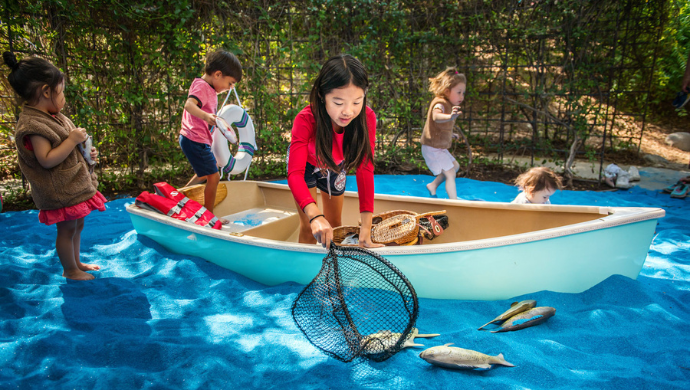 Children play in boat in blue sand lake