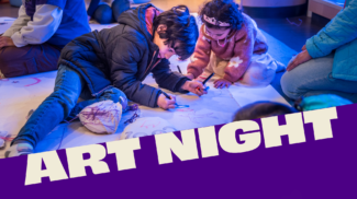 Two children drawing on a large paper mural