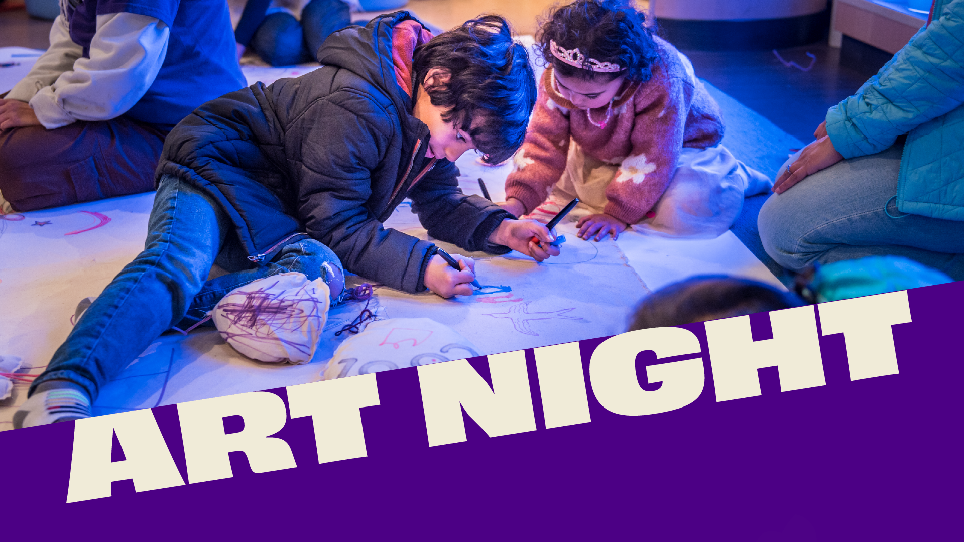 Two children drawing on a large paper mural