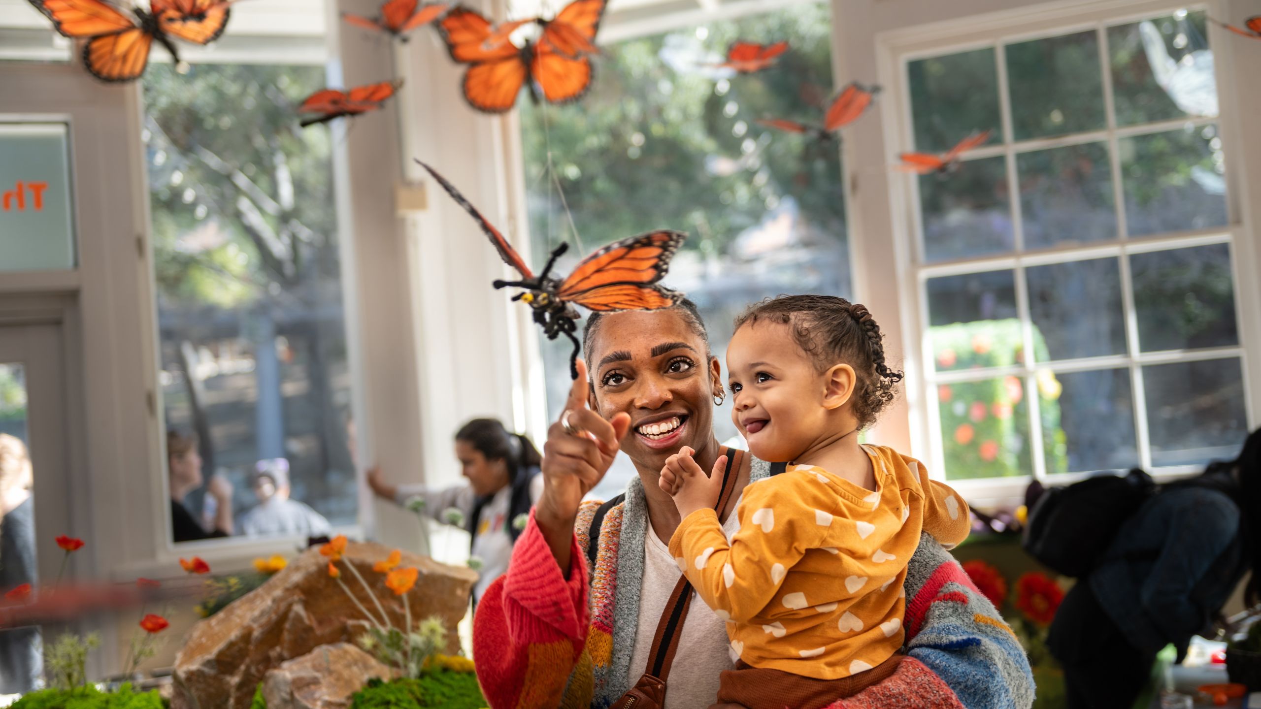 Parent and child look at a butterfly sculpture
