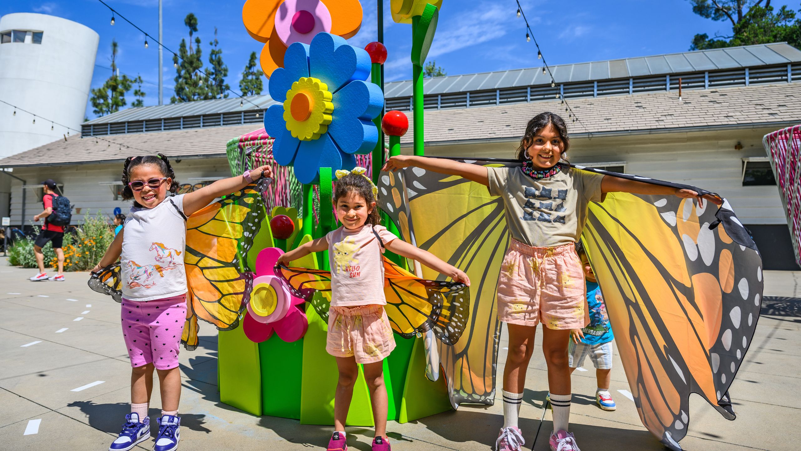 Three girls spread their playful butterfly wings
