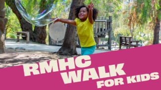 Child in yellow chases a bubble