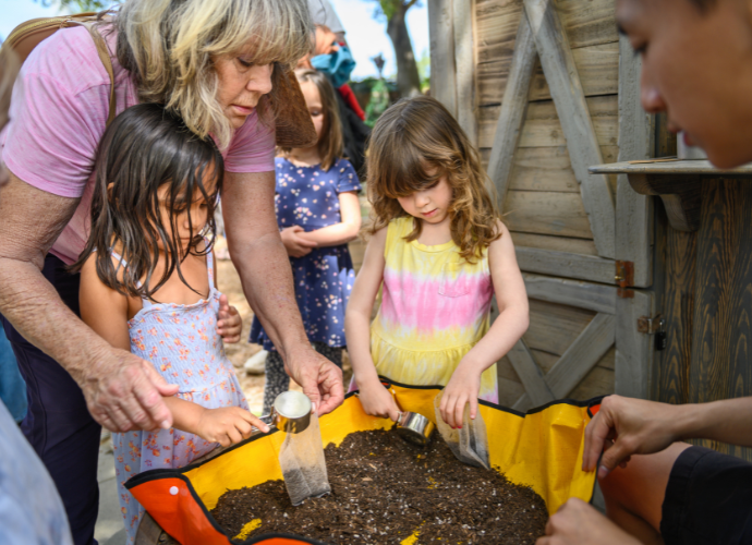 children and adult planting seeds